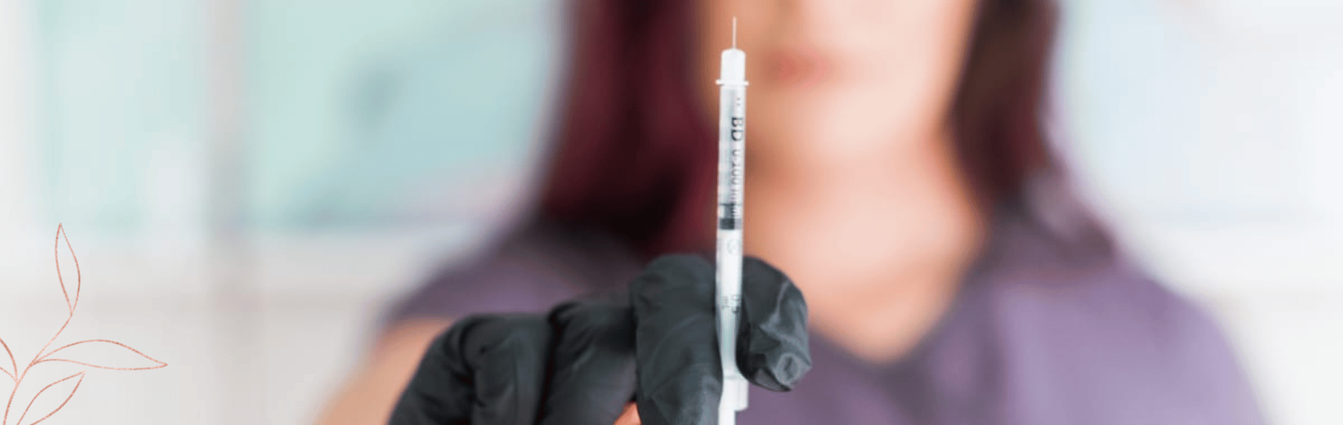 female blurred facial feature holding close up on fillers needle towards camera